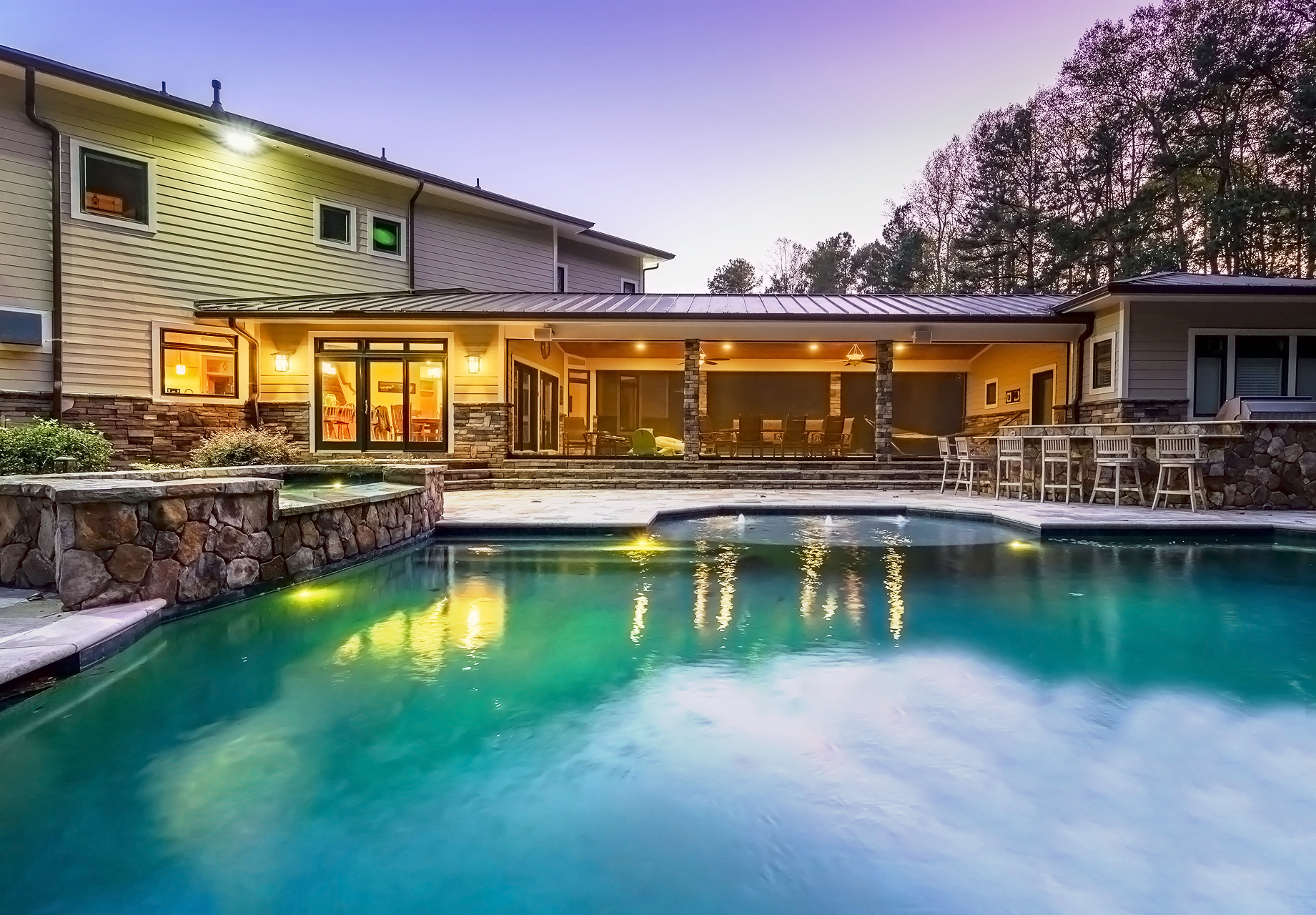 Backside of custom home with pool and hot tub 